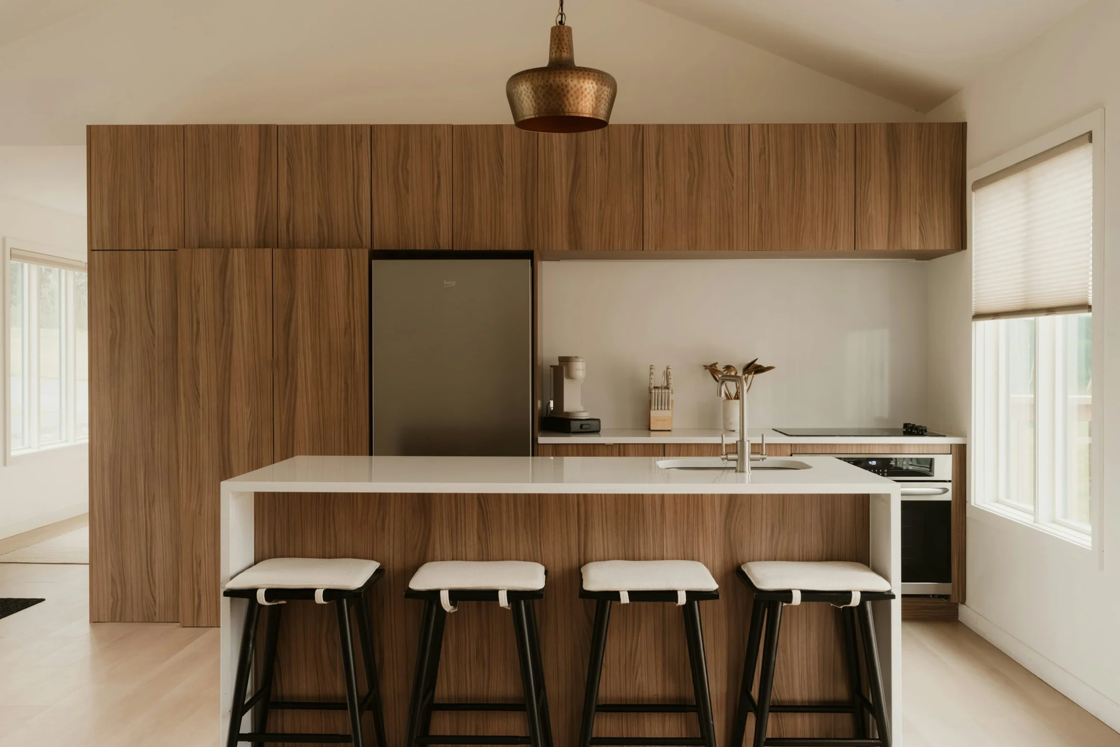 Illustrative stock photograph of a refined oak kitchen with a stone island and natural light